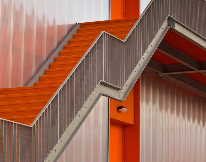 Orange escape stairs on the outside of a modern building